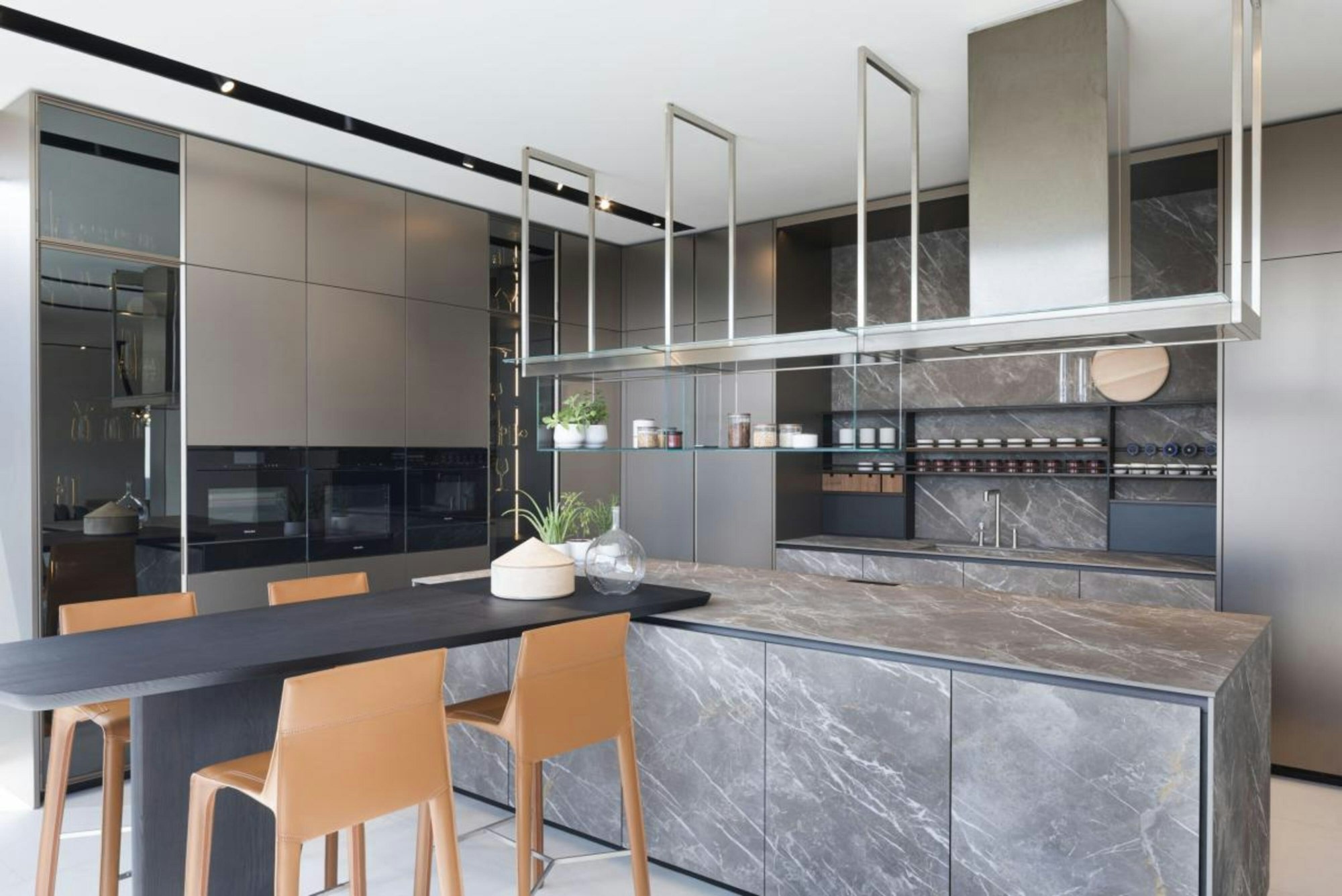 Cozinha contemporânea com ilha em pedra e armários por medida